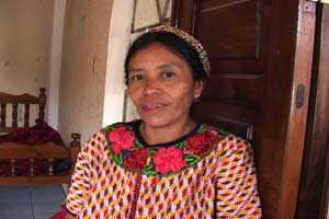 María Sanchez, mother of 8, wears a cinta or ribbon around her head and a huipil typical of her community.  Both are hand woven. María has taught all her daughters the art of weaving their own clothes.