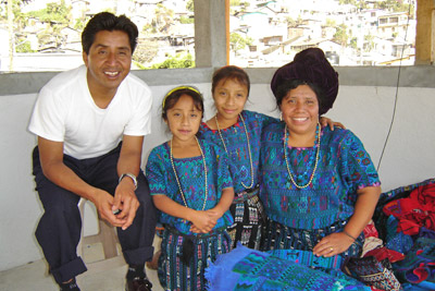 Weaver and international traveler Albertina Lopez, of Santa Catarina Palopó, sits on the rooftop deck of her home with her husband, Gregorio Martin Cumes and their two daughters Sandy and Melissa.  Photo by Denise Gallinetti 2005.