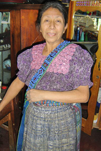 Maximina Yojcon works with a small weavers' group in San Pedro La Laguna and sells their products.  The belt over her shoulder was woven by María Ixmataj with a maguey weft for stiffness, and was beaded by María Gonzales.  Photo by Denise Gallinetti 2005.