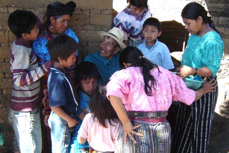 Lucas Patsún Mendosa, a maguey worker visiting from the neighboring community of San Marcos, is surrounded by Pablo's wife, María Ixcaya, and their extended family.  Photo by Denise Gallinetti 2005.