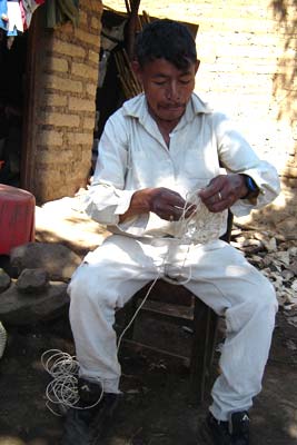 Pablo Rasam is making a looped bag of spun maguey fiber that he has purchased rather than processed himself. He has worked with maguey all his life, though now he also works with spun plastic.  Photo by Denise Gallinetti 2005.