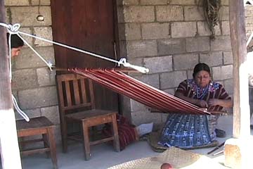 Gregoria Rucuch Cumes sets up her backstrap loom to weave the dark red cloth used in a Patzún-style huipil.  Photo by Kathleen Mossman Vitale 2005.