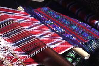 Santiaga weaves a heavily brocaded huipil panel using red and white warps.  Photo by Kathleen Mossman Vitale 2005.