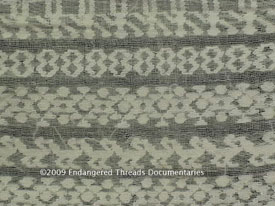 Picb'il design rows of dolls (muñecos SP), figure eights, stars & planets, and domestic fowl. The designs are made by supplementary weft brocade on a spaced or gauze weave textile on a backstrap loom.