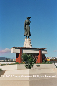 The Maya woman's statue at the entrance to 'Xela', was designed in 1953 and constructed in 1977.  Today, women in traje are rare, and rarer still is anyone wearing the wide head wrap in the busy city. Photo by Cheryl Guerrero 2005.