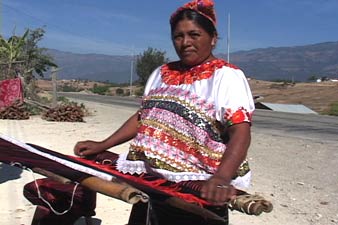 Andrea Raymundo wears the traditional traje of the Aguacatán area and weaves by the roadside.  Photo by Kathleen Mossman Vitale 2005.