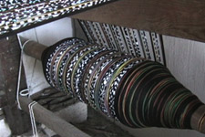 A huge roll of warp threads is at the ready at the far end of the huge floor loom Carlos uses.  Carlos learned weaving from his own father.  Photo by Kathleen Mossman Vitale 2004.