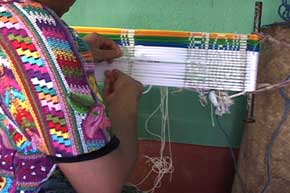 María Estela ties cotton thread bundles at specific intervals, according to a planned sequence.  The area underneath the ties remains undyed, and produces a pattern when woven.  Photo by Kathleen Mossman Vitale 2005.