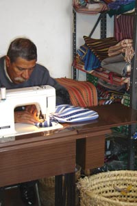 Oswaldo Moreira Mendes, a longterm employee of Culibrí in Antigua, sews back strap loomed fabric into carrying bags.  Photo by Denise Gallinetti 2005.