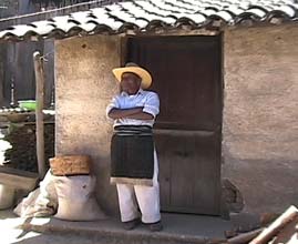 Cristobal Rucuch, 80, watches his daughter Gregoria weave in the family compound in Patzún.  He wears a rodillillera around his waist over his pants, a custom still practiced by some older indigenous men in the area.  Photo by Kathleen Mossman Vitale 2005.