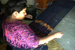 Juana Lopez, Nahualá, wears a traditional huipil of her community.  She is reconstructing her tenter and chocoy or shed rod after her son pulled out all the sticks while she was away at the market.  Photo by Kathleen Mossman Vitale 2004.