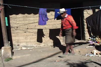 Antonio Lopez, seen here working in the family compound, wears the traditional men's traje of Nahualá, consisting of a red back strap woven shirt and a brown checkered rodillera or hip wrap made of wool.  Photo by Kathleen Mossman Vitale 2005.