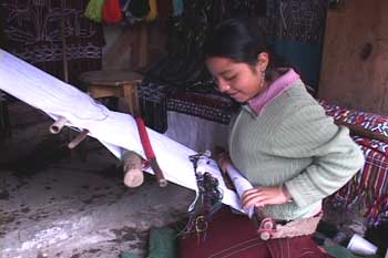 Helena Estella Covo Santiago, 14, sets up a back strap loom in her small stall in Nebaj where she works fulltime, having been forced by family circumstances to leave school in fifth grade.  Photo by Kathleen Mossman Vitale 2005.