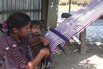 Elena Domingo Mejía weaves on her back strap loom next to her daughter Lilia.  They live near the community of San Rafael Petzal in Huehuetenango.  Photo by Kathleen Mossman Vitale 2005.